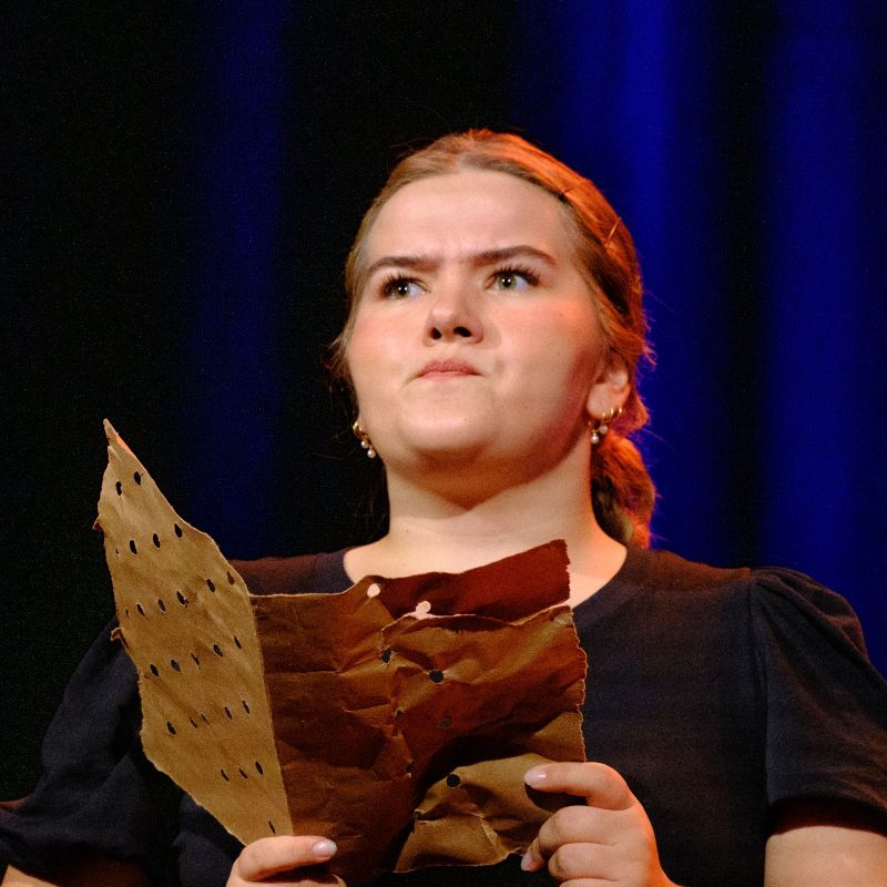 A young girl is contemplating the content of a letter.