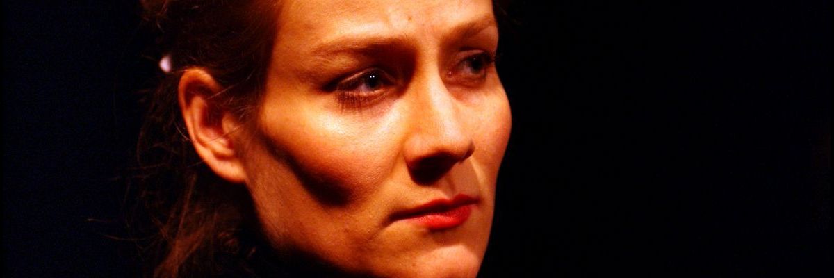 Head shot of a woman (Amelia) without a necklace. Her facial exprssion is composed and contemplative.