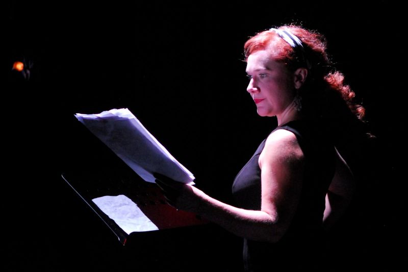 Hedda on her own in the recording studio looking at her script.